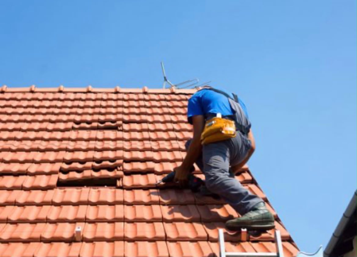 Roofer repairing terracotta tile roof